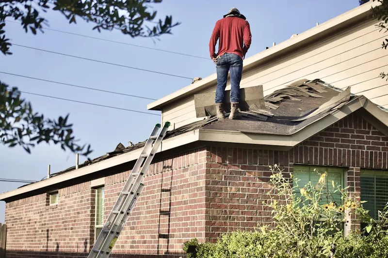 Professional roofer working on a residential roof in Greenway Court
